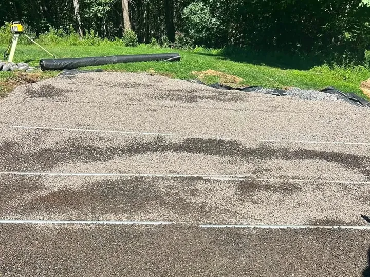 Graded gravel base with string lines set in a backyard before a patio was built
