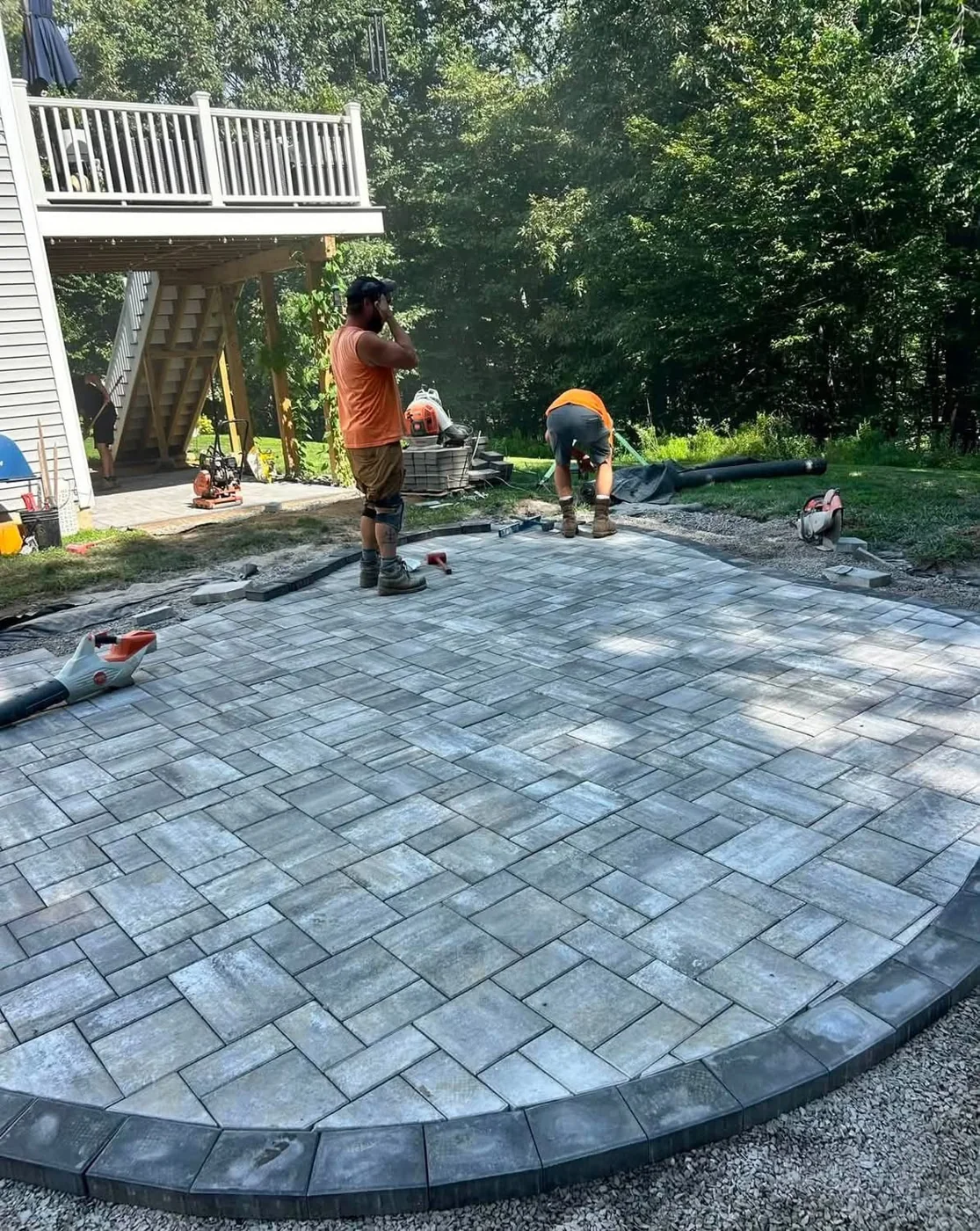 Up North Scapes crew setting pavers by hand on the compacted base