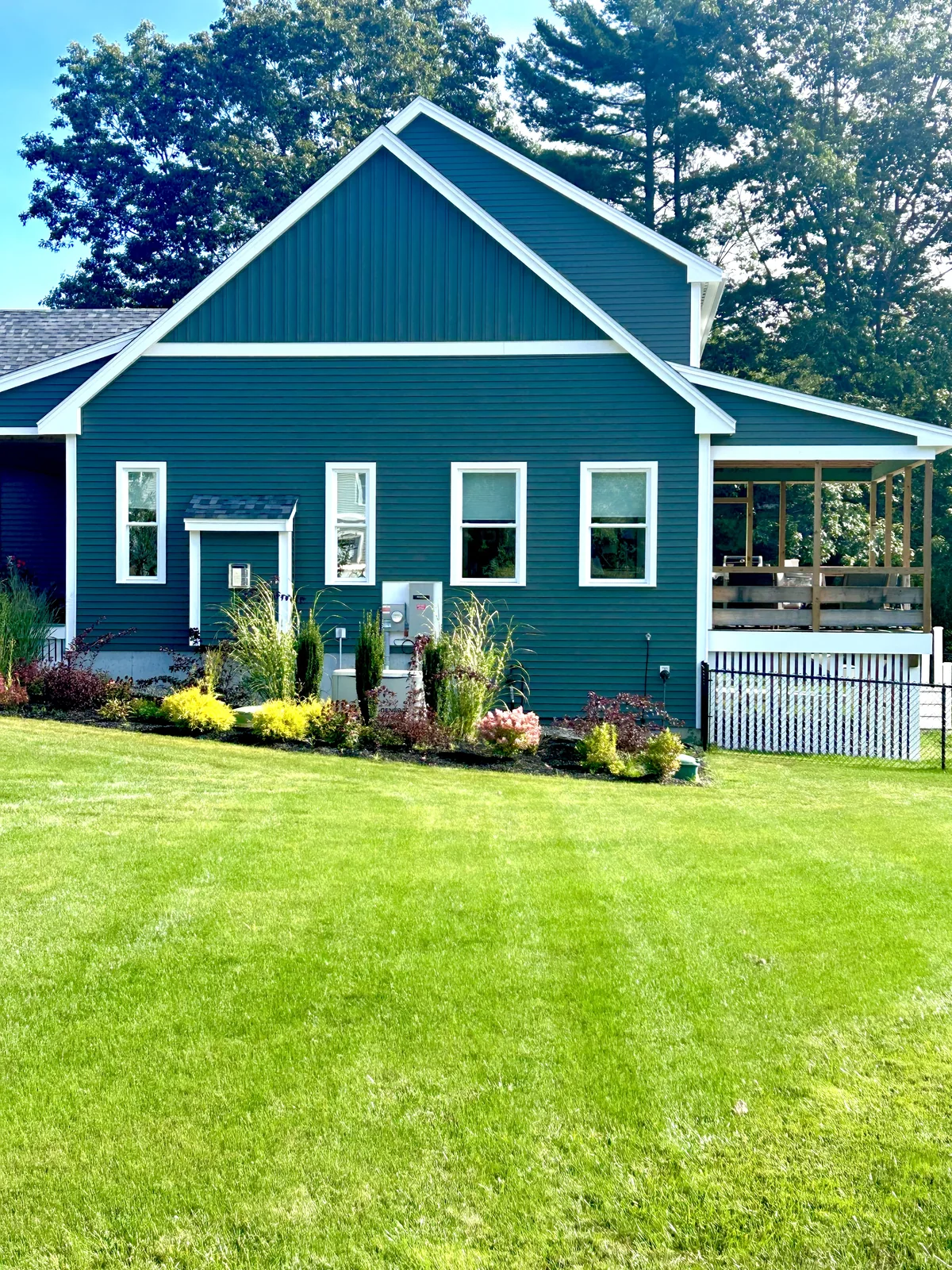 Fresh foundation planting bed and lawn at a teal house - Up North Scapes NH