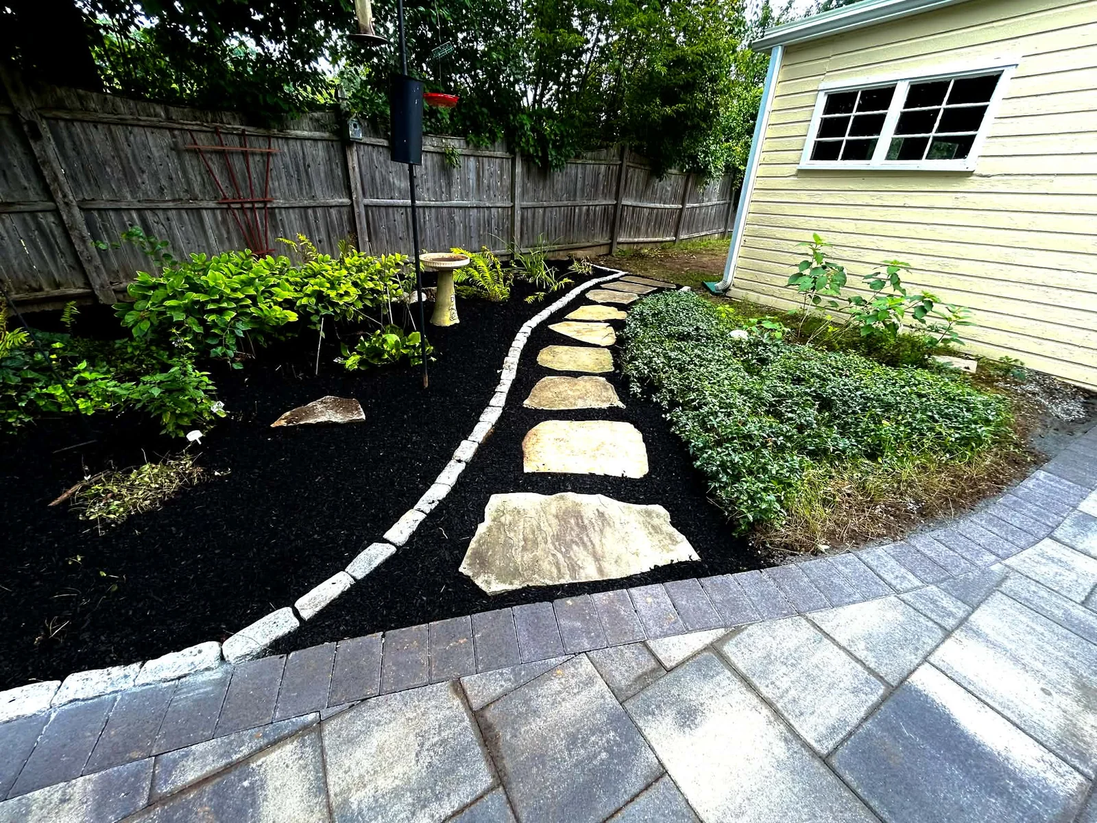 Natural stone stepping path with cobble edging and paver walkway installed by Up North Scapes