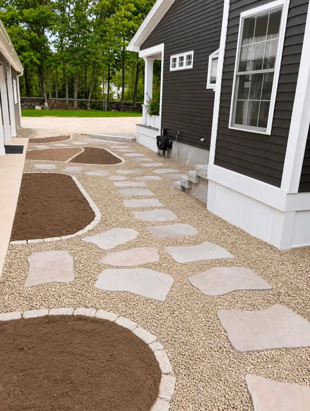 Flagstone steppers set in pea gravel between curved planting beds