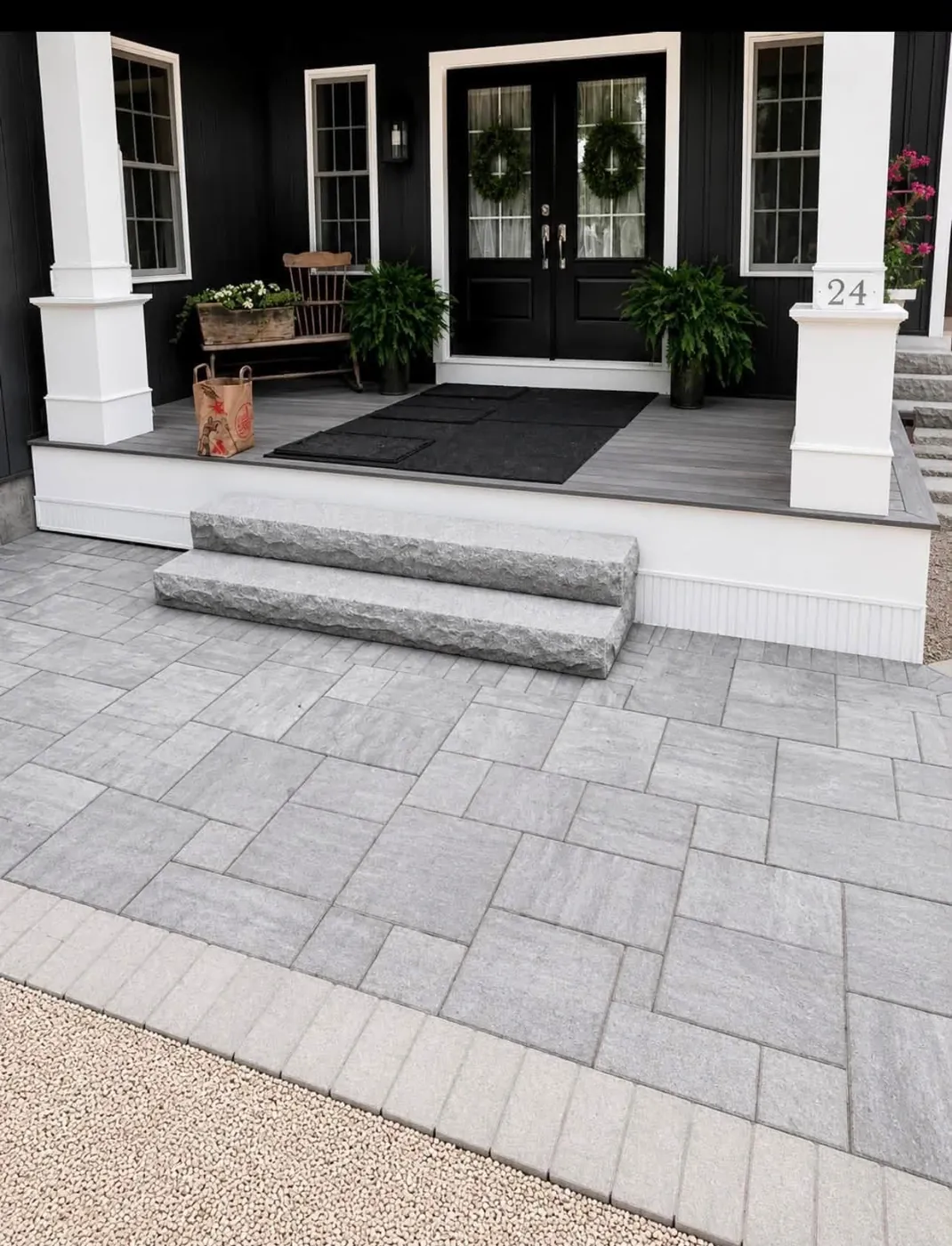 Wide granite step rising from a grey paver landing to a porch with double doors