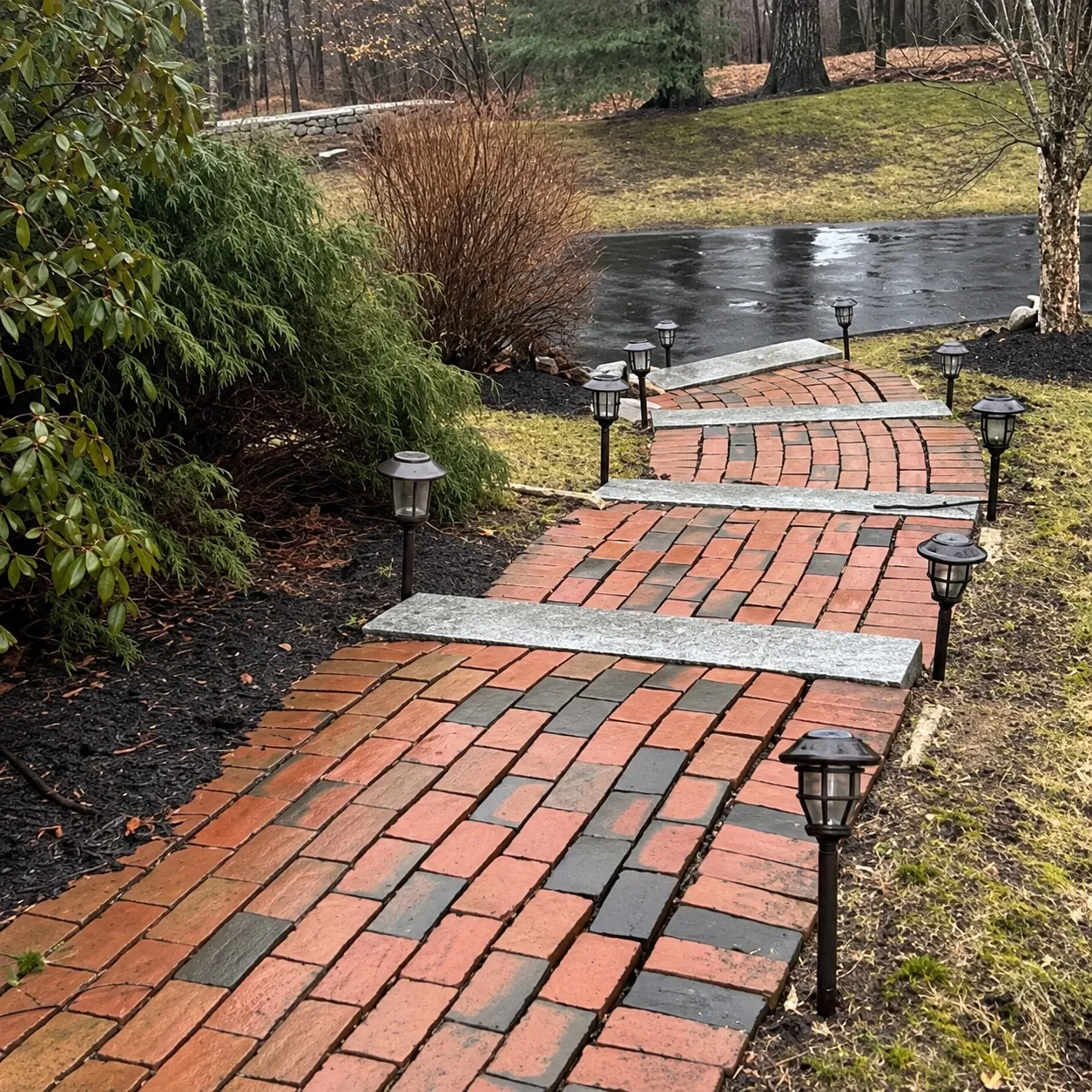 An old brick walk with granite treads stepping down a slope