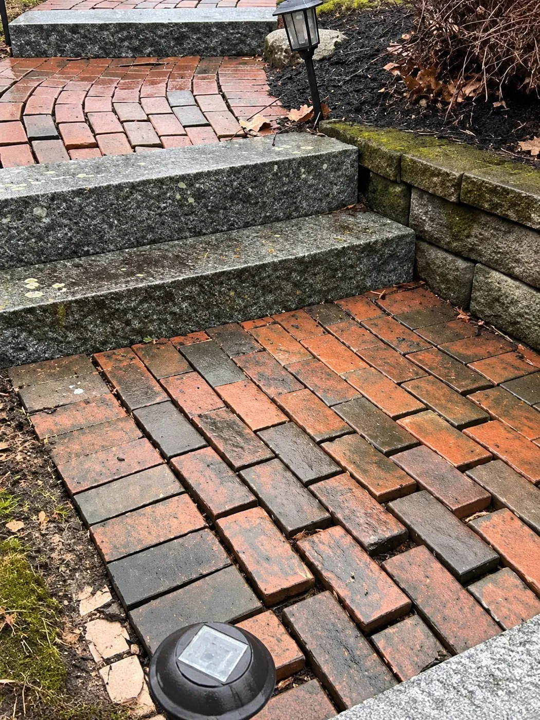 Old brick that has heaved beside a granite tread