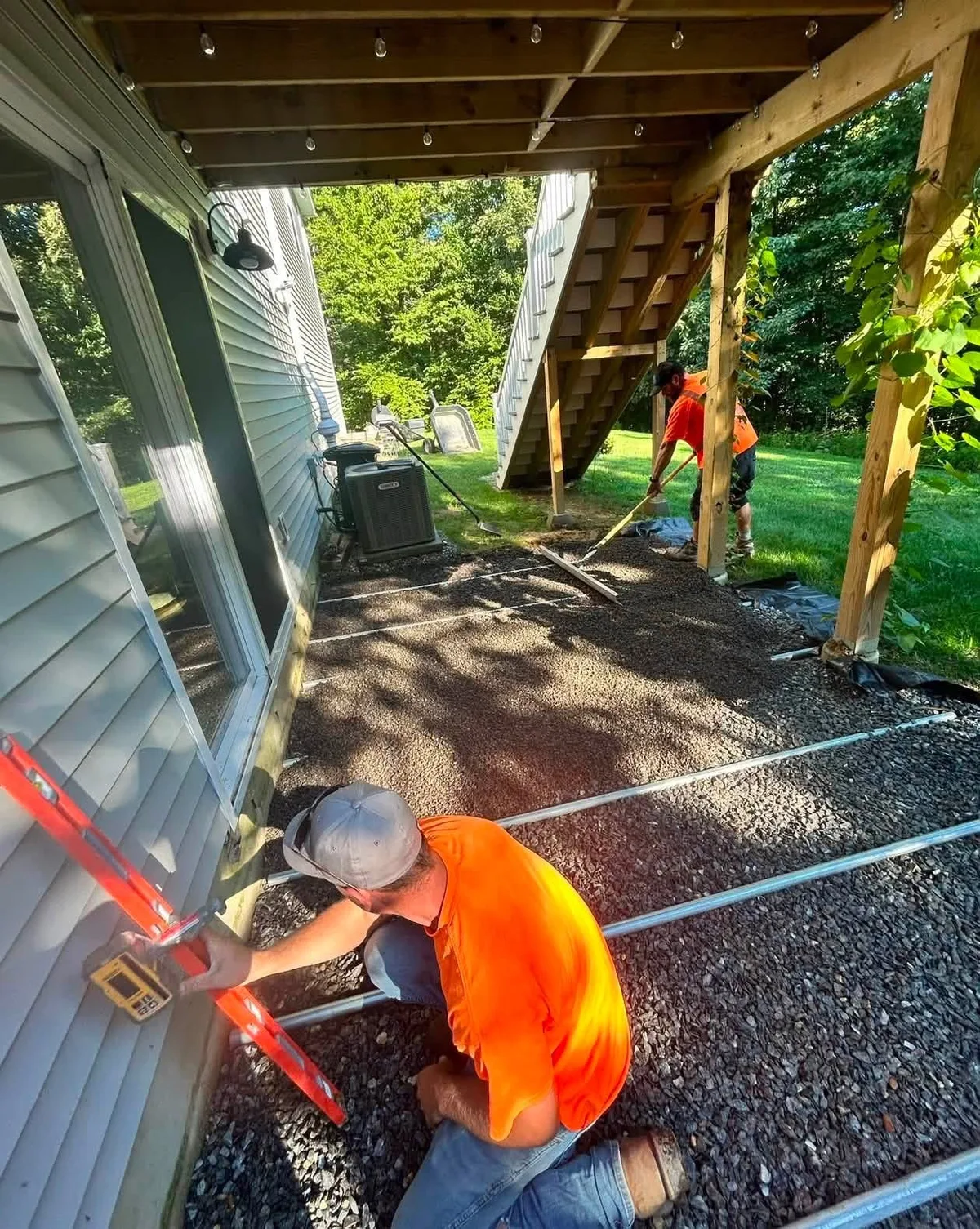 Crew checking grade over a compacted base before the surface goes down