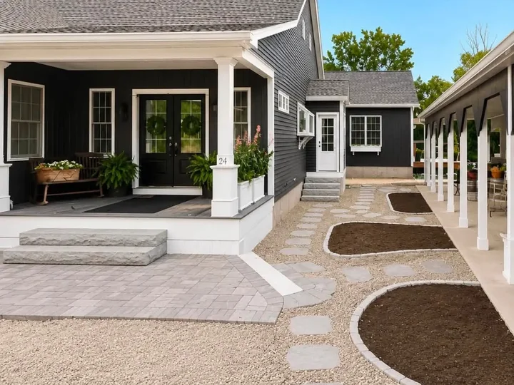 Grey paver landing with flagstone steppers in pea gravel along a covered porch