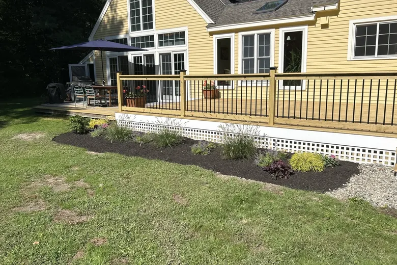Easy care plants and a small tree set along the front of a new deck