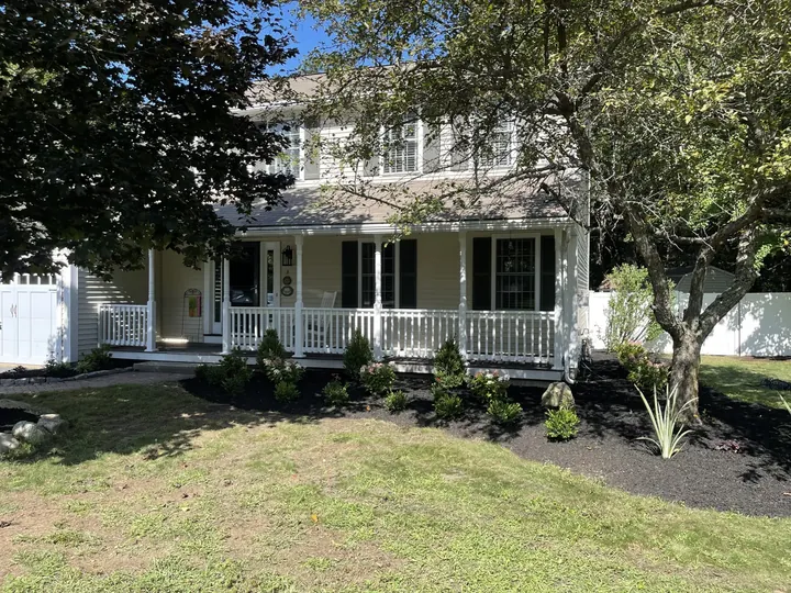 New shrubs and perennials along a white porch