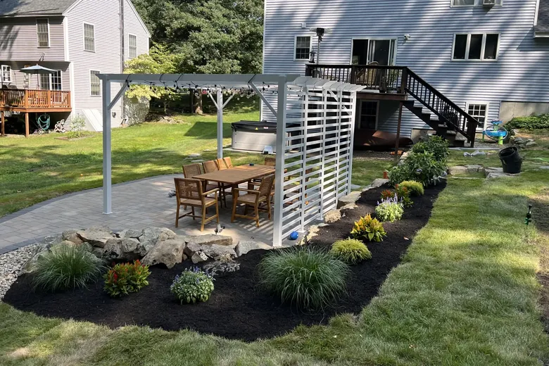 Planting bed along a pergola beside a backyard patio