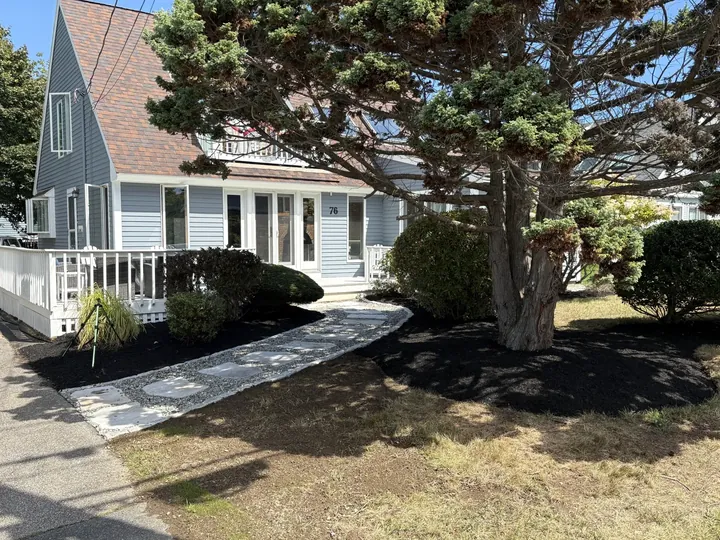 Mulched beds along a walk beside a house