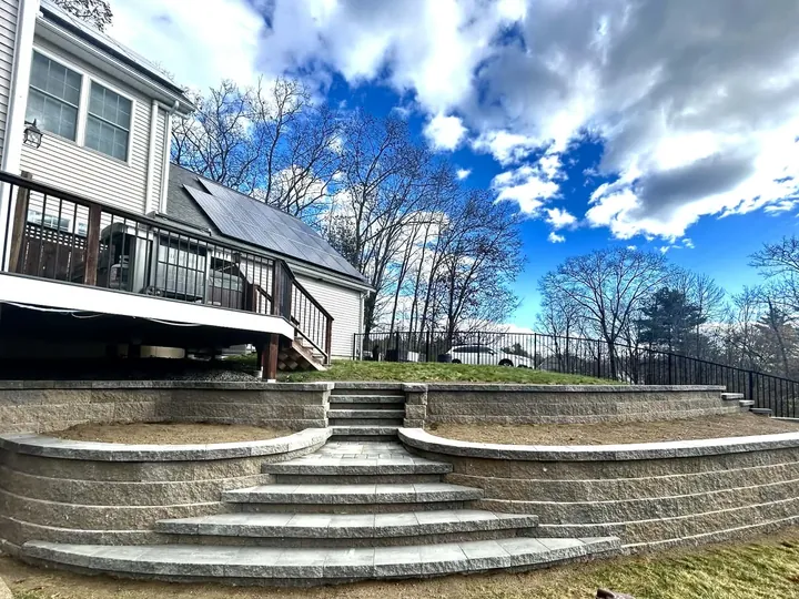 Curved block walls stepping down from a deck with wide steps