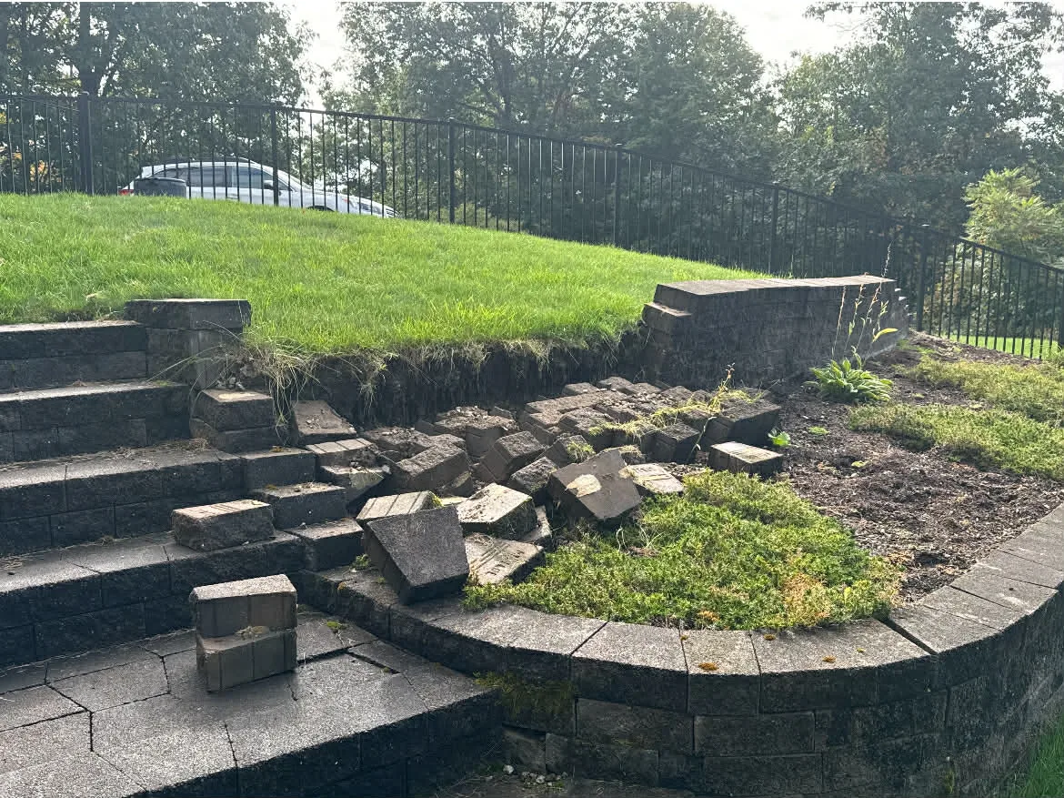 Collapsed block retaining wall with blocks down on the steps below it