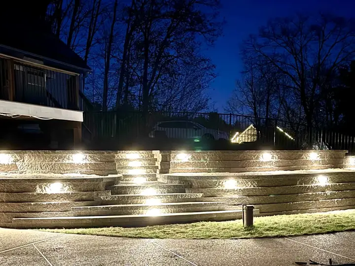 Tiered retaining wall and steps lit at night with built in lights